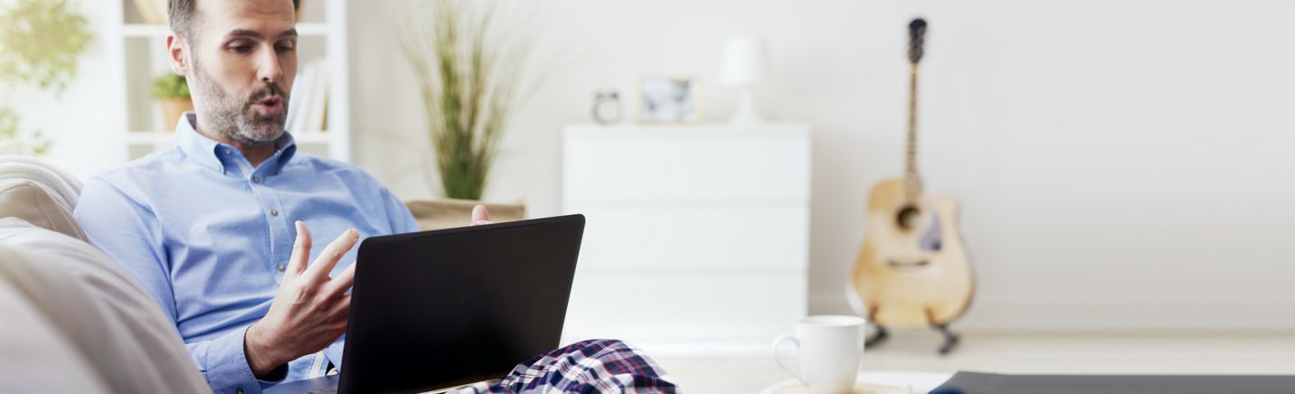 Man working from home on video call in pajama pants