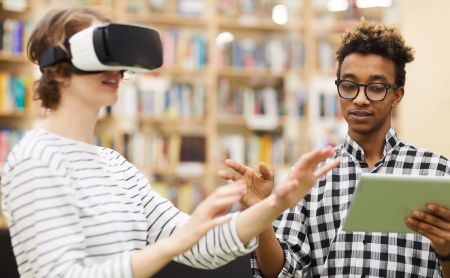 Two students using virtual reality goggles to study for exams