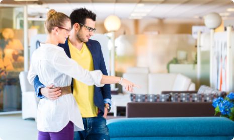 Happy couple shopping for a new sofa in a furniture showroom